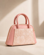 Blush pink rose mini dome bowling bag for women with floral emboss detail gold hardware and clover charm top handle luxury style 2026