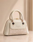 Cream off white mini dome bag for women with floral emboss detail rose gold hardware black clover charm detachable crossbody strap luxury style 2026