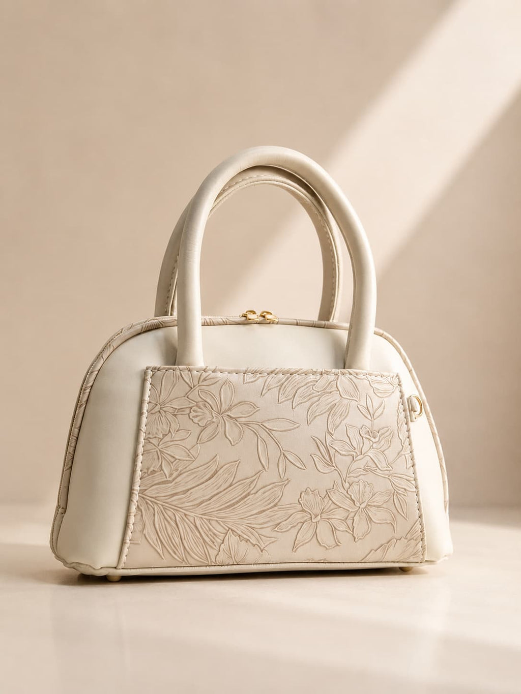 Cream off white mini dome bag for women with floral emboss detail rose gold hardware black clover charm detachable crossbody strap luxury style 2026