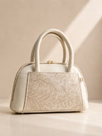 Cream off white mini dome bag for women with floral emboss detail rose gold hardware black clover charm detachable crossbody strap luxury style 2026