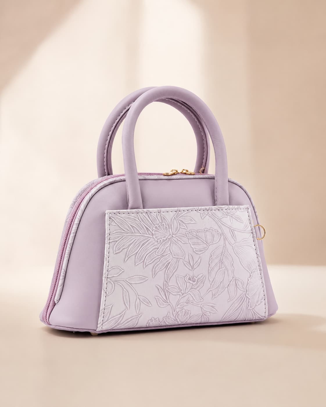 Lavender lilac mini dome bowling bag for women with floral emboss detail gold hardware and clover charm top handle luxury style 2026