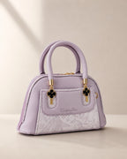 Lavender lilac mini dome bowling bag for women with floral emboss detail gold hardware and clover charm top handle luxury style 2026